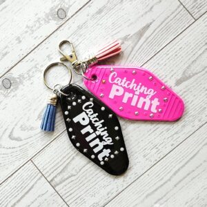 Catching Print Motel Keychain — Funny Cheeky Bag Charm with Studs and Tassel